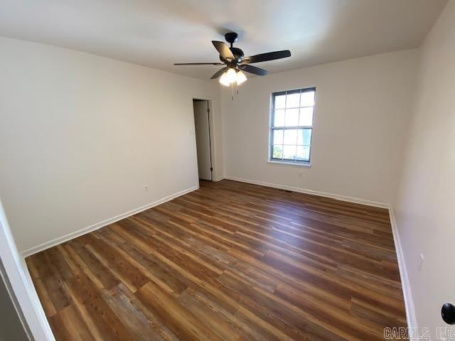 spare room with dark wood-type flooring and ceiling fan