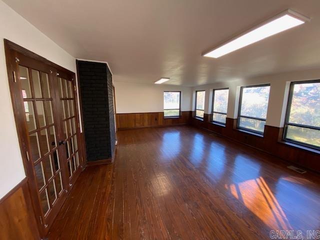 spare room with dark wood-type flooring and wood walls