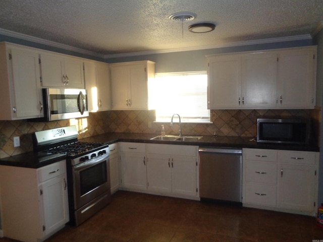 kitchen featuring white cabinetry, sink, decorative backsplash, appliances with stainless steel finishes, and ornamental molding