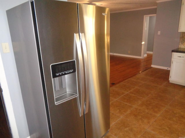 kitchen featuring stainless steel fridge, light hardwood / wood-style flooring, and white cabinetry