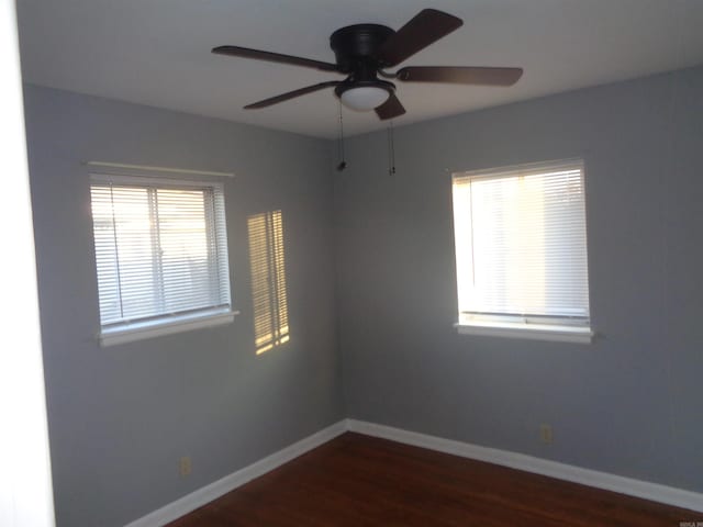 unfurnished room with dark hardwood / wood-style flooring and ceiling fan