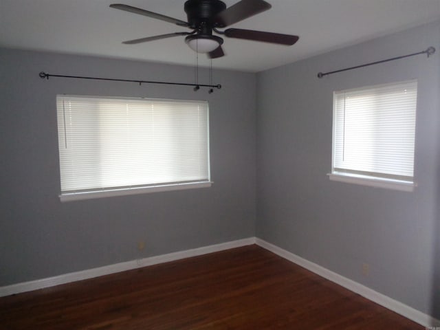 empty room with ceiling fan and dark wood-type flooring