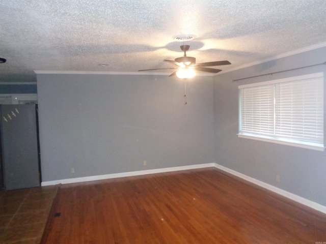 spare room featuring a textured ceiling, dark hardwood / wood-style flooring, and crown molding