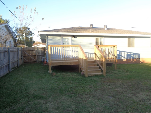 rear view of house with a yard and a deck