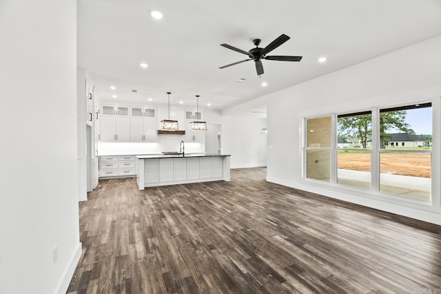 unfurnished living room featuring ceiling fan, sink, and dark hardwood / wood-style floors