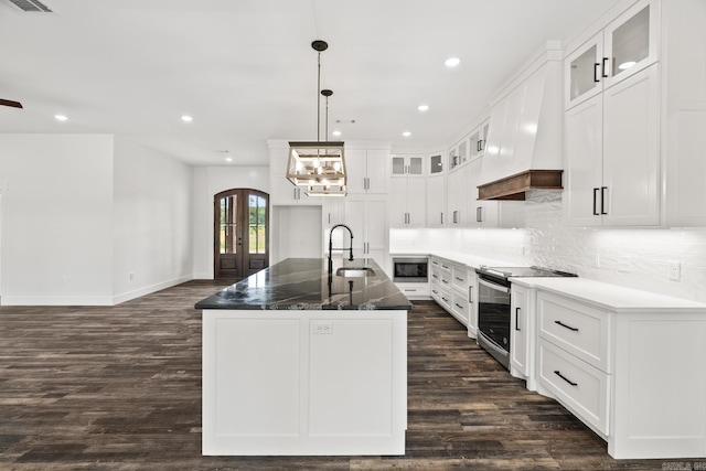 kitchen with sink, white cabinetry, stainless steel appliances, and a kitchen island with sink