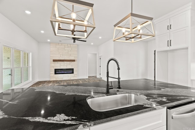 kitchen featuring sink, dark stone countertops, and hanging light fixtures