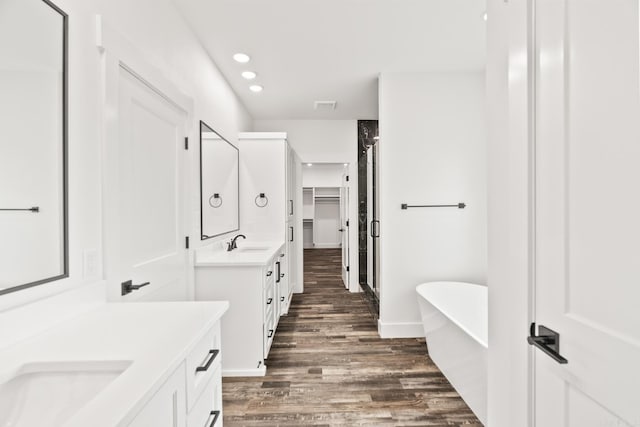 bathroom featuring hardwood / wood-style floors, vanity, and shower with separate bathtub