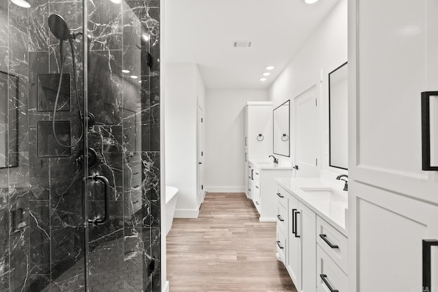 bathroom featuring plus walk in shower, vanity, and hardwood / wood-style flooring