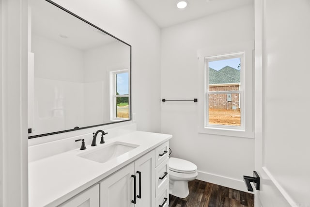 bathroom with toilet, vanity, and hardwood / wood-style flooring