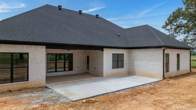 rear view of property featuring ceiling fan and a patio