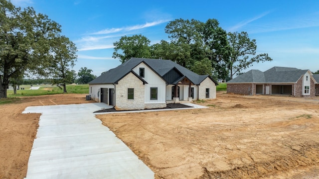 modern farmhouse style home with a garage and central air condition unit