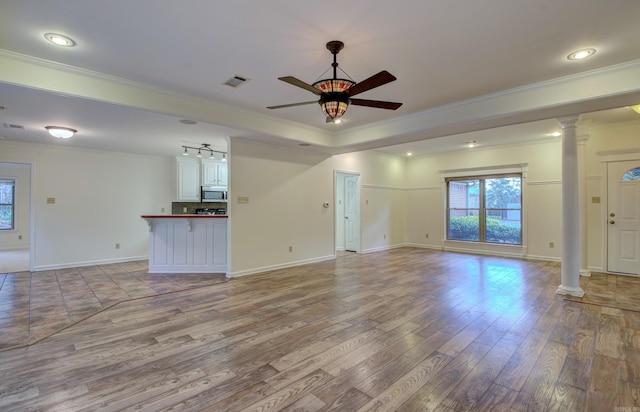 unfurnished living room with light hardwood / wood-style floors, ornate columns, and crown molding