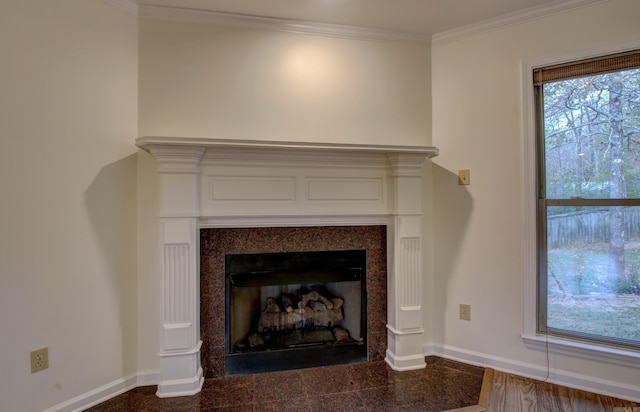 interior details with a tiled fireplace, wood-type flooring, and ornamental molding