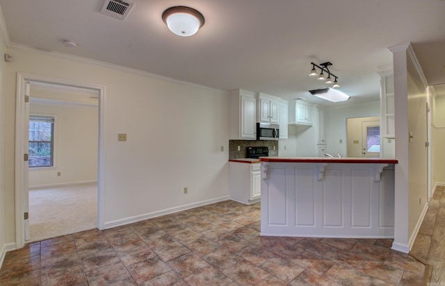 kitchen with kitchen peninsula, ornamental molding, tasteful backsplash, white cabinetry, and a breakfast bar area