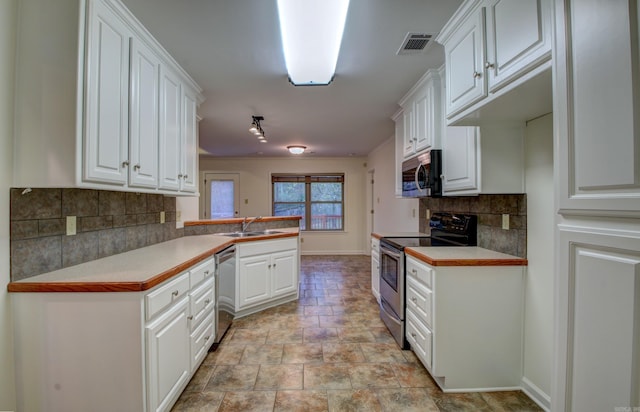 kitchen featuring white cabinets, kitchen peninsula, and stainless steel appliances