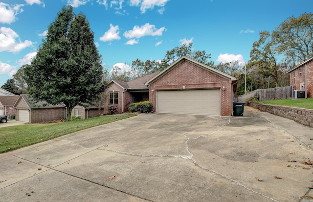 view of front of property with central AC, a front yard, and a garage