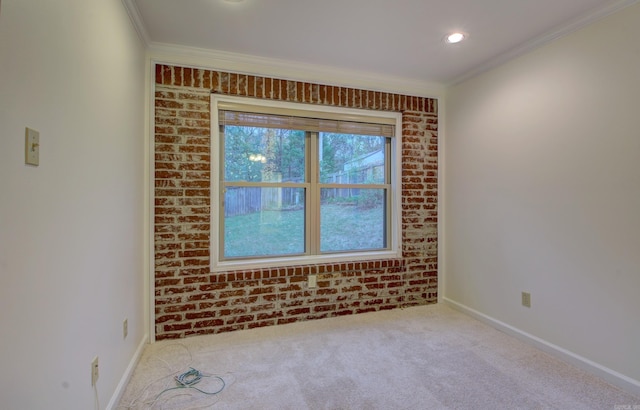 empty room featuring light colored carpet, brick wall, and ornamental molding