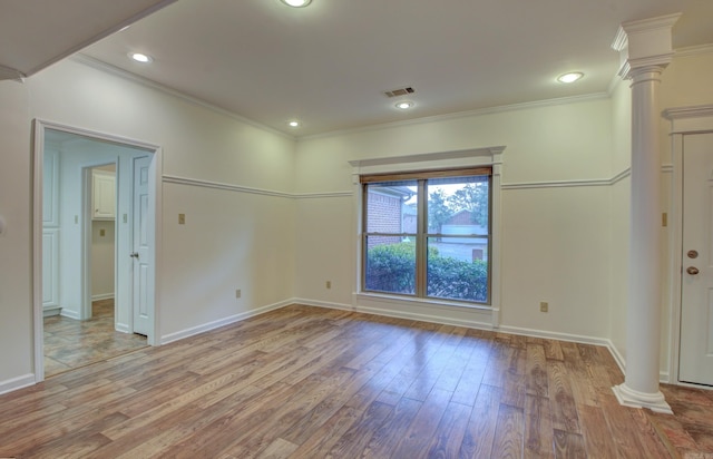 unfurnished room with decorative columns, light hardwood / wood-style flooring, and ornamental molding