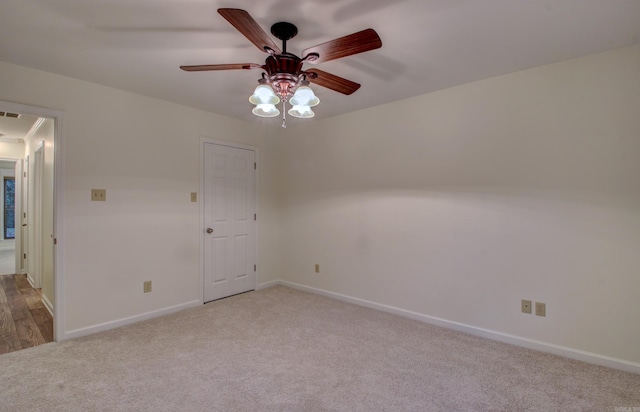 carpeted empty room featuring ceiling fan