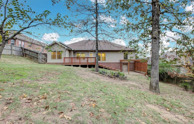 rear view of property featuring a yard and a wooden deck