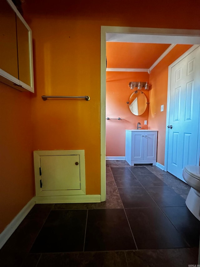 bathroom featuring tile patterned flooring, vanity, toilet, and ornamental molding