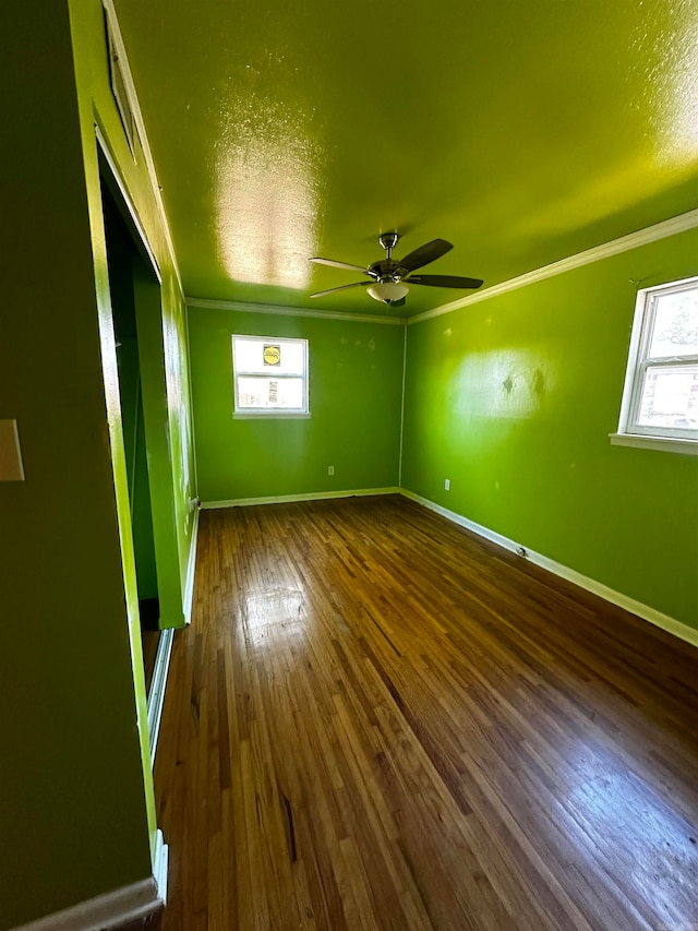 empty room featuring dark hardwood / wood-style floors, ceiling fan, and ornamental molding