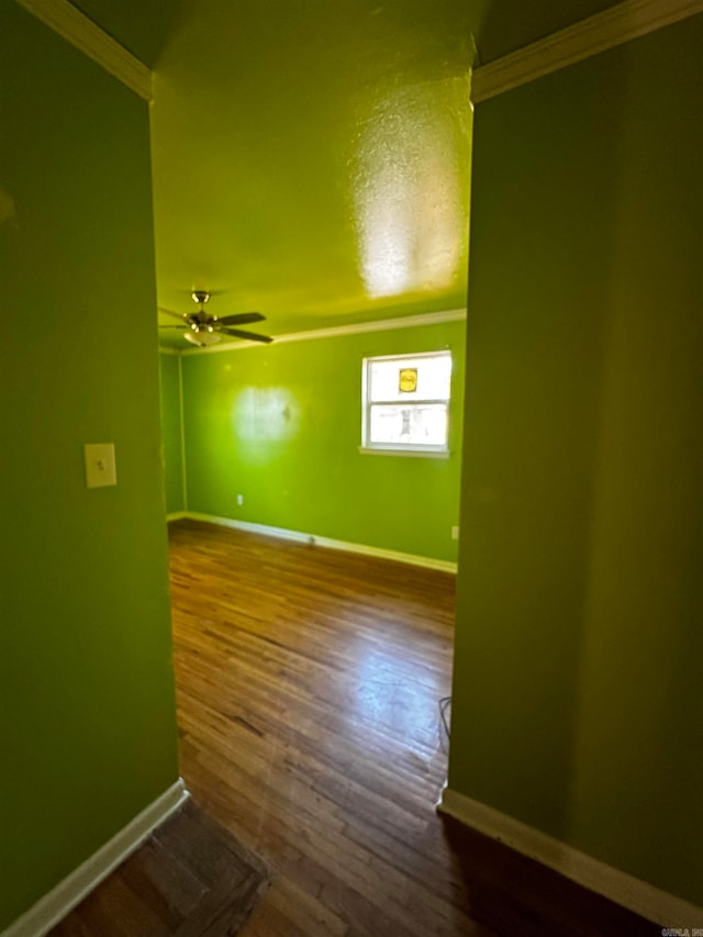 unfurnished room featuring ceiling fan, wood-type flooring, and ornamental molding