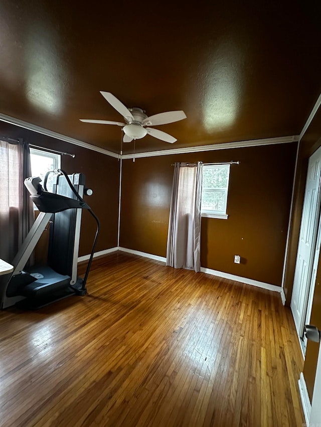 exercise room featuring hardwood / wood-style flooring, ceiling fan, and crown molding