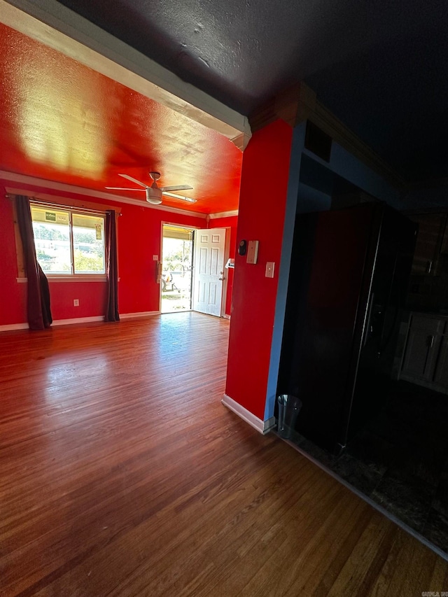 empty room with ceiling fan, a textured ceiling, and hardwood / wood-style flooring