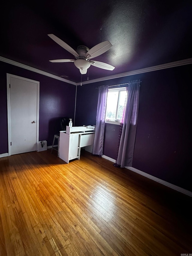 empty room featuring hardwood / wood-style flooring, ceiling fan, and crown molding