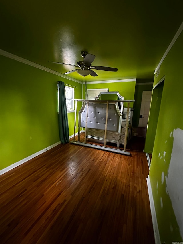 unfurnished bedroom featuring ceiling fan, dark hardwood / wood-style floors, and ornamental molding