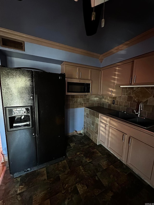 kitchen with decorative backsplash, black refrigerator with ice dispenser, and sink