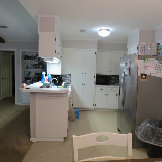 kitchen with decorative backsplash, stainless steel fridge, kitchen peninsula, crown molding, and white cabinets