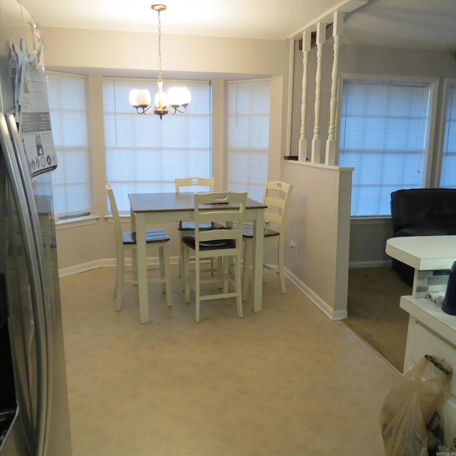 dining area featuring carpet and a notable chandelier