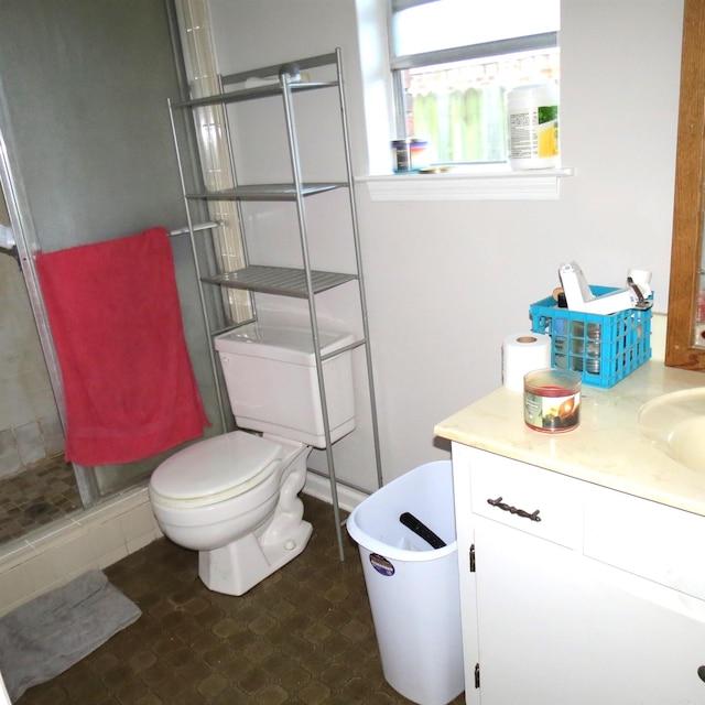 bathroom featuring vanity, toilet, and an enclosed shower