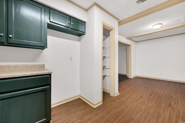 kitchen with green cabinetry and hardwood / wood-style flooring