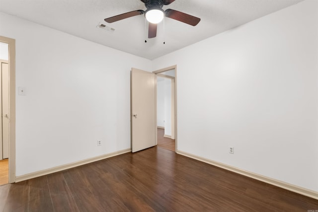 empty room featuring ceiling fan and dark hardwood / wood-style flooring