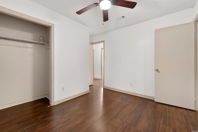 unfurnished bedroom with a closet, ceiling fan, and dark hardwood / wood-style flooring