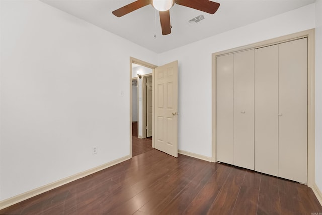 unfurnished bedroom featuring dark hardwood / wood-style floors, ceiling fan, and a closet