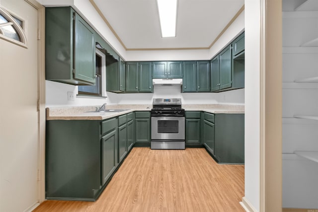 kitchen featuring stainless steel gas range oven, sink, green cabinetry, and light wood-type flooring