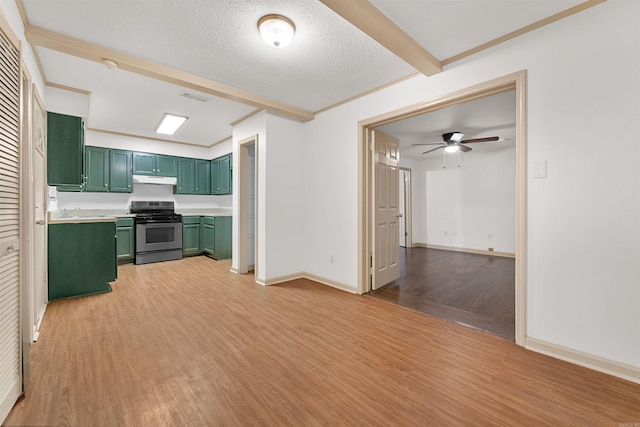 kitchen with a textured ceiling, light wood-type flooring, green cabinets, and stainless steel gas range