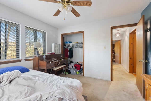 carpeted bedroom featuring ceiling fan, a closet, and a textured ceiling