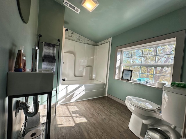 bathroom with shower / bathing tub combination, hardwood / wood-style floors, toilet, and lofted ceiling