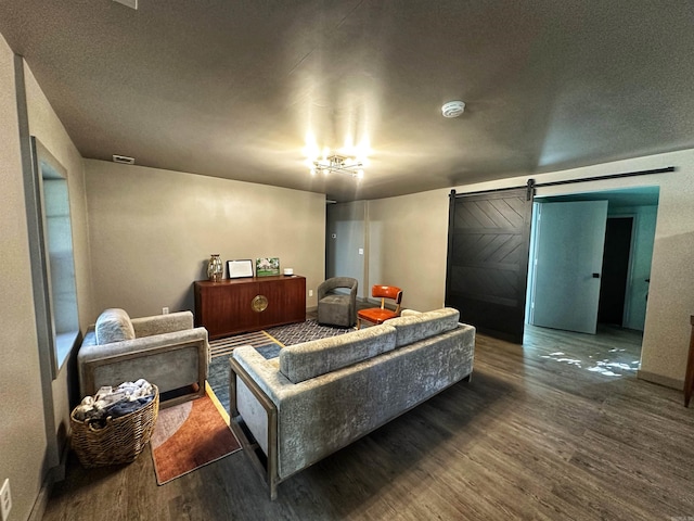 living room with a barn door and hardwood / wood-style flooring