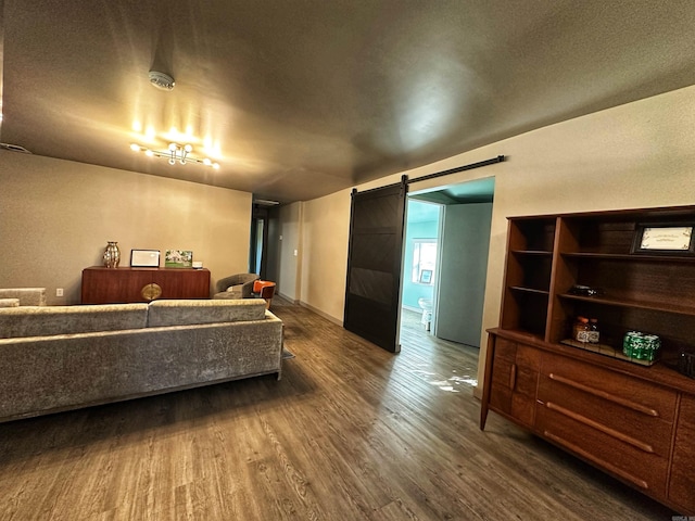 living room featuring a textured ceiling, a barn door, and dark wood-type flooring