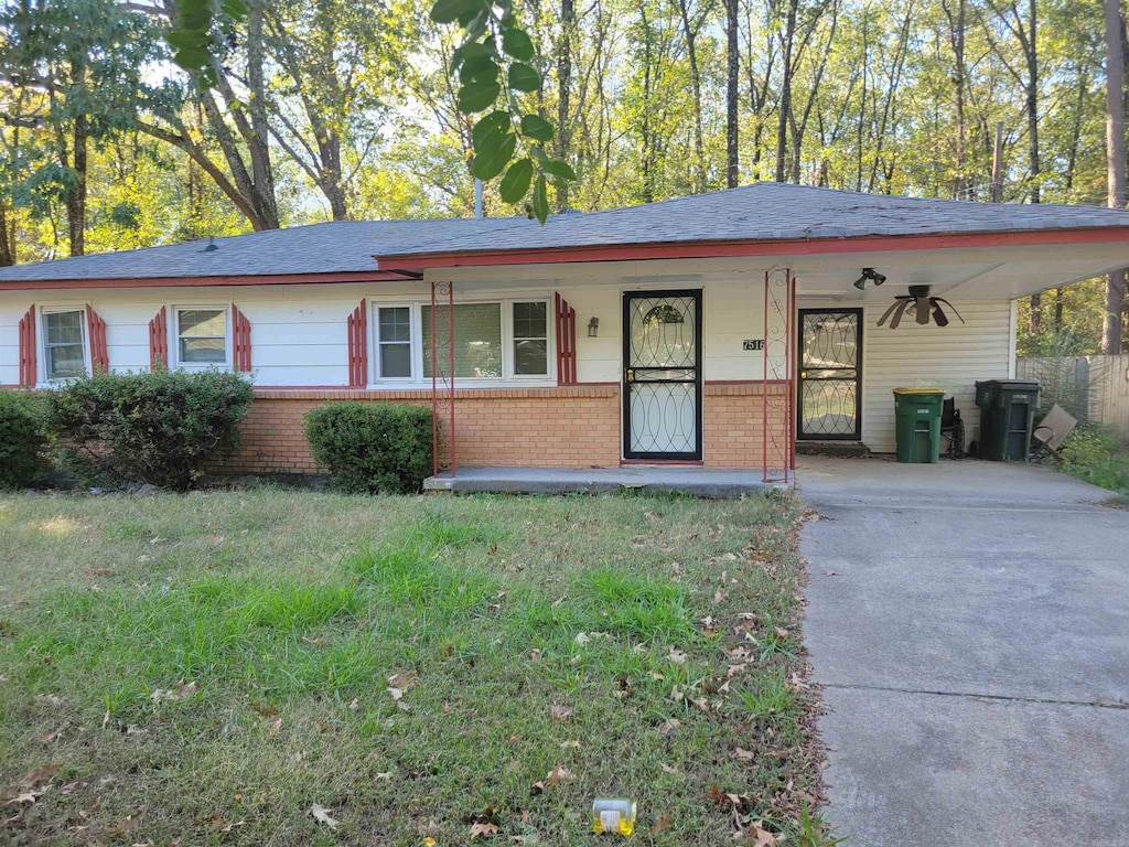 single story home featuring a carport, covered porch, and a front lawn