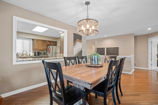 dining space with light wood-type flooring and an inviting chandelier