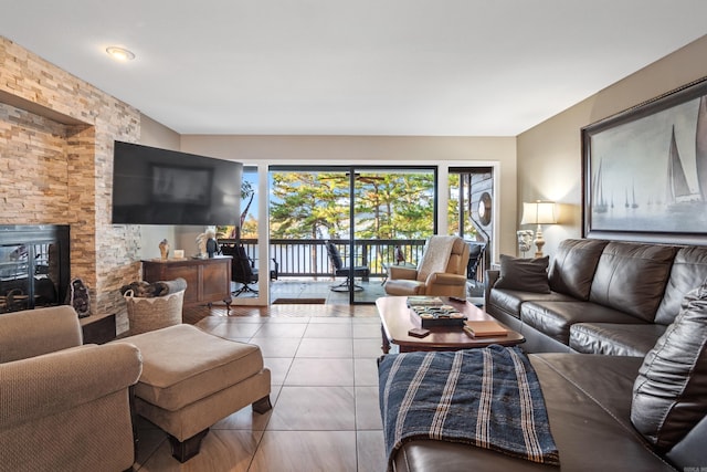 living room featuring tile patterned flooring and a stone fireplace