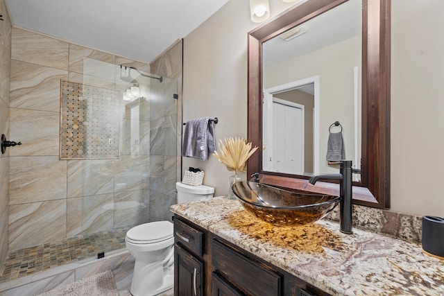 bathroom featuring vanity, toilet, and tiled shower